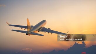 Passanger airplane flying above clouds in evening.